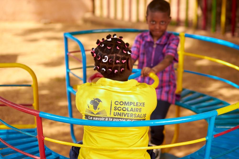Enfant de maternelle en tenue jaune Universalis, dans la cour de récréation